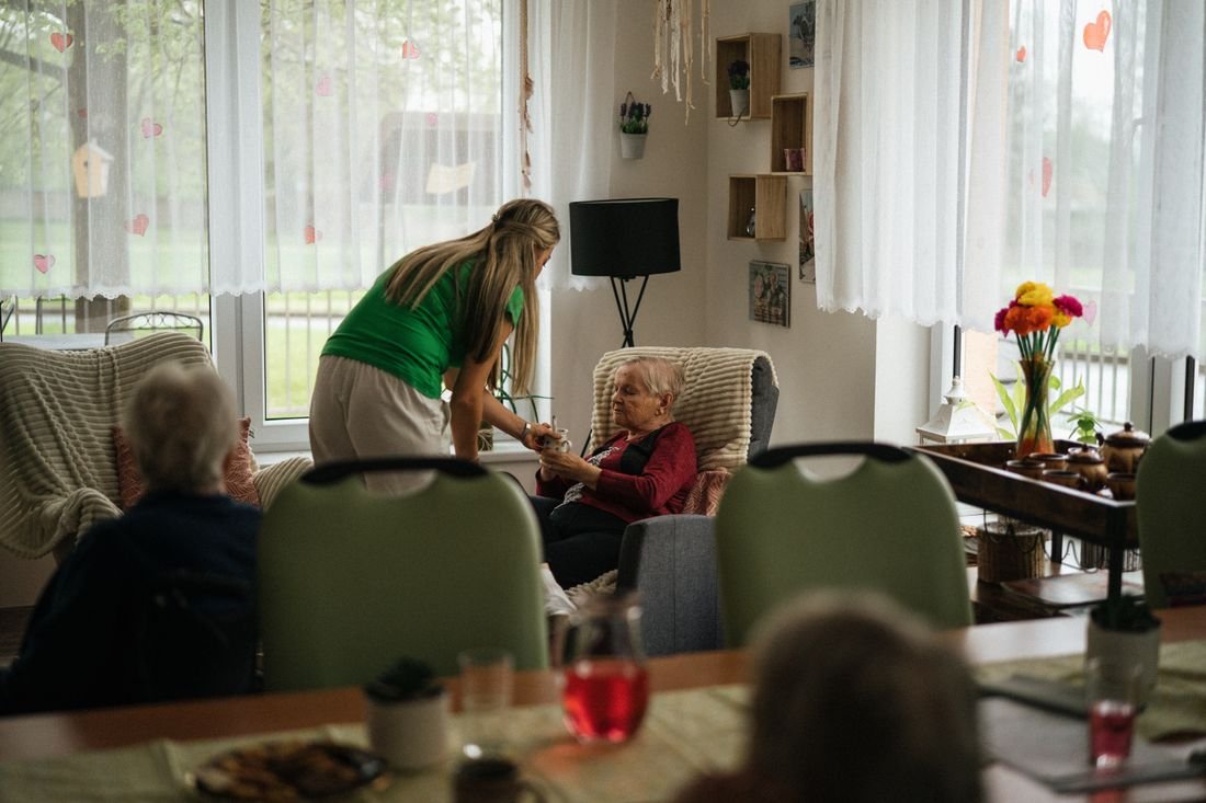 Alltagsbegleiterin unterstützt eine ältere Frau zu Hause